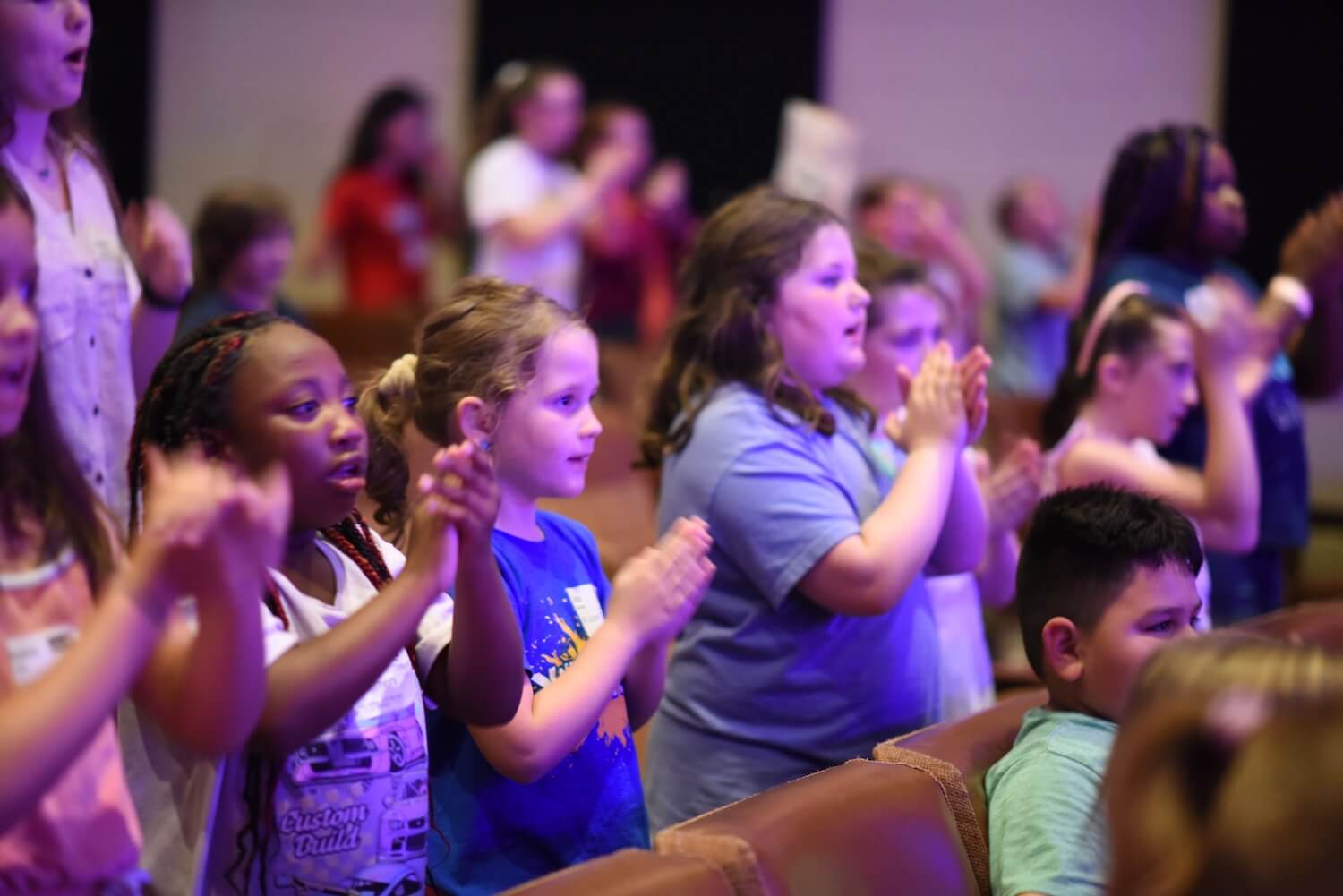 Children worshipping with hands raised at KidzFest