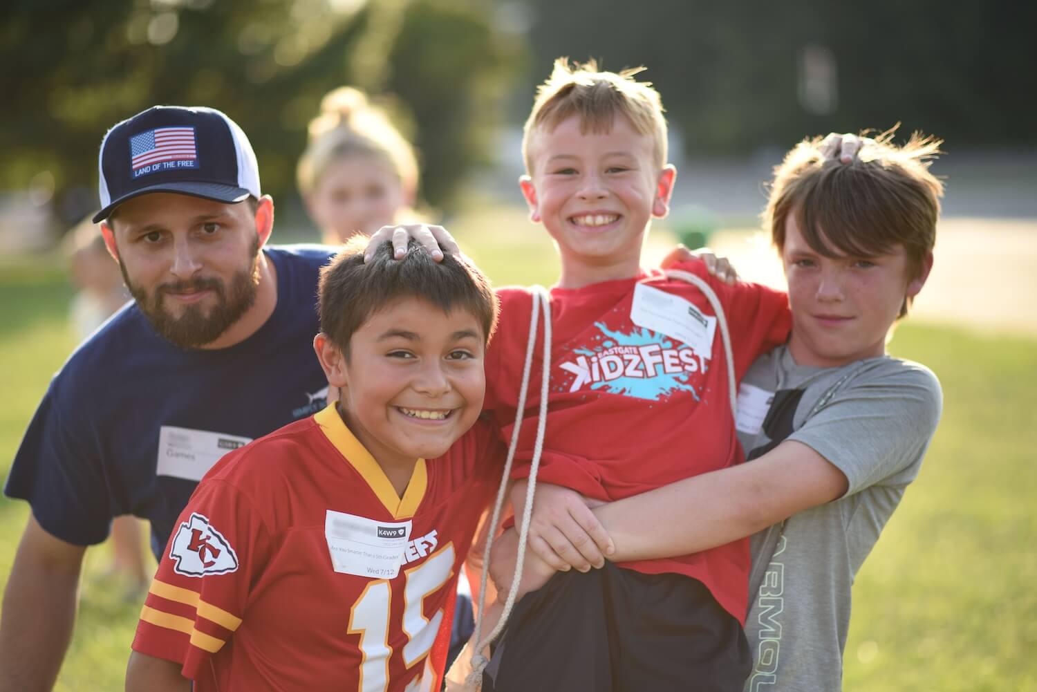 A leader with three smiling campers at golden hour