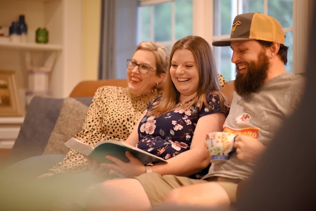 A community group laughing together over an open Bible